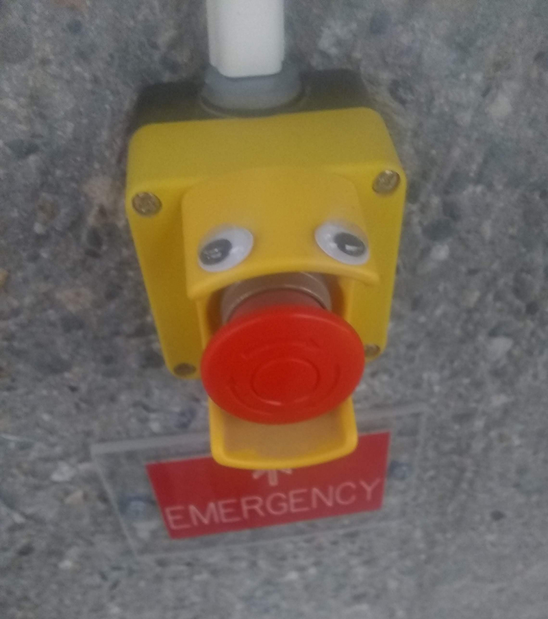 Googly eyes on an Emergency button, making the button look like a tongue sticking out.