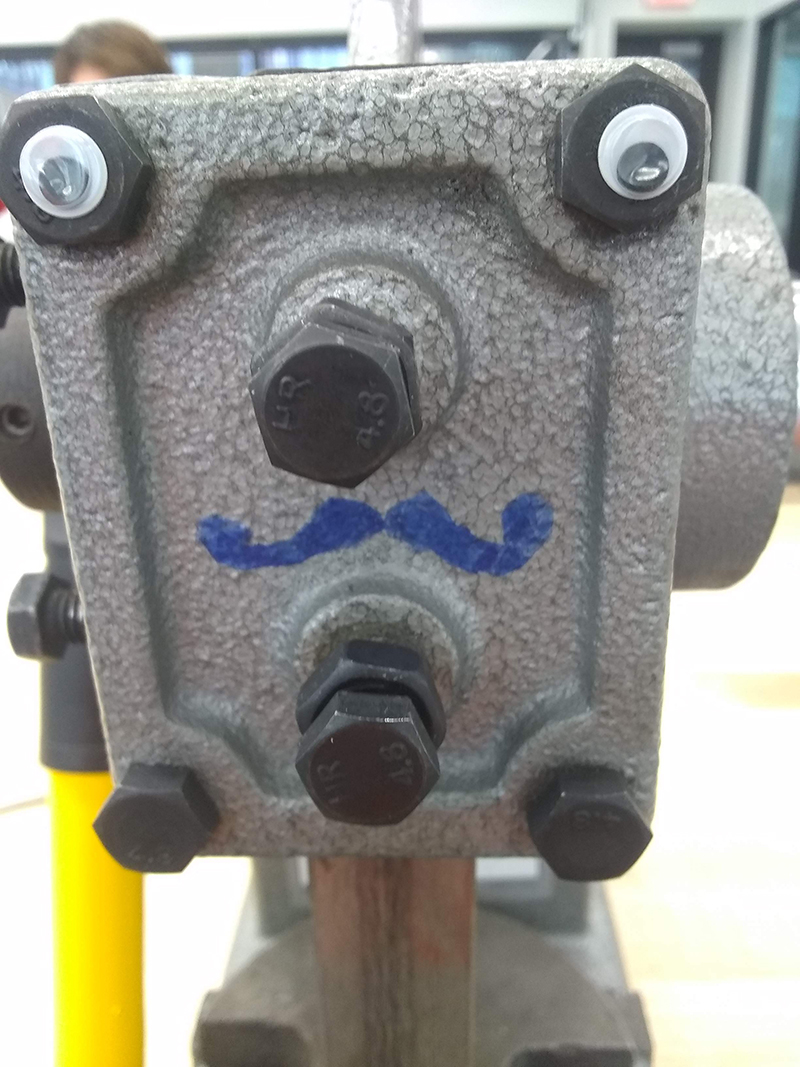 Two googly eyes on the front of the same device. Someone has drawn a moustache on, too.