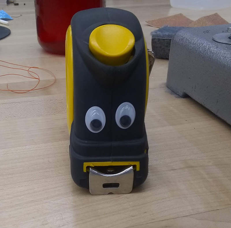 Googly eyes on a tape measure. The tape looks like buck teeth.