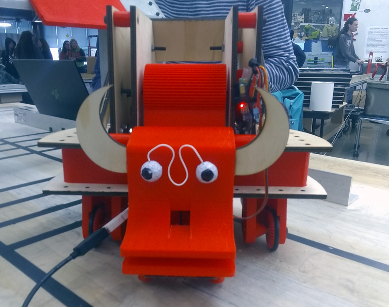 Foil-wrapped chocolate eyes on a red wheeled robot with devil-like horns.