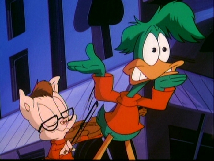 Porky Pig dressed as JF playing a violin, while Plucky Duck dressed as Linnell dances.